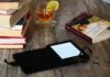 El eterno debate entre los lectores: libros en digital o en papel E-reader sobre una mesa con libros en papel