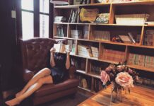 Las novedades literarias españolas que hacen soñar Mujer leyendo en sillón ante su estantería