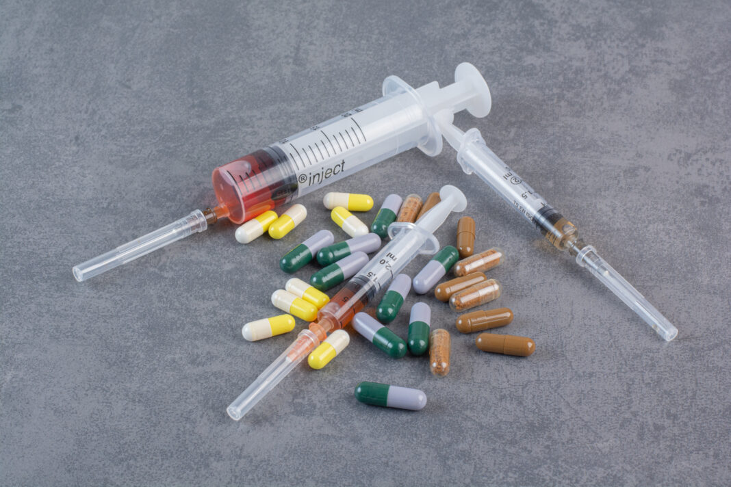 Assorted pharmaceutical capsules and syringes with serums